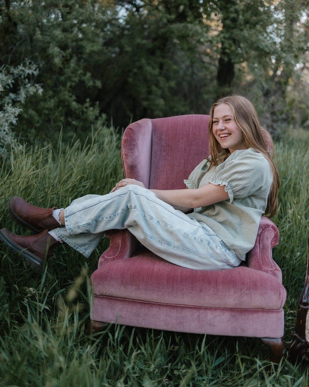 Emma relaxing in a pink armchair in a field